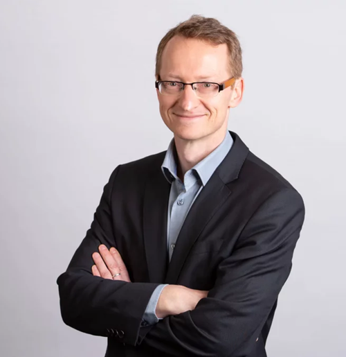 Portrait of Jon Whittle arms crossed facing the camera and smiling