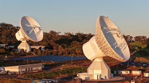 ESA's New Norcia ground station in Western Australia, two large antennas shown standing taller than the surrounding trees and buildings.