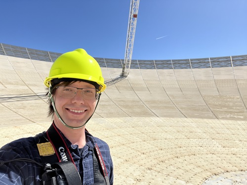 Dr Lower wearing a protective helmet on a radio telescope.