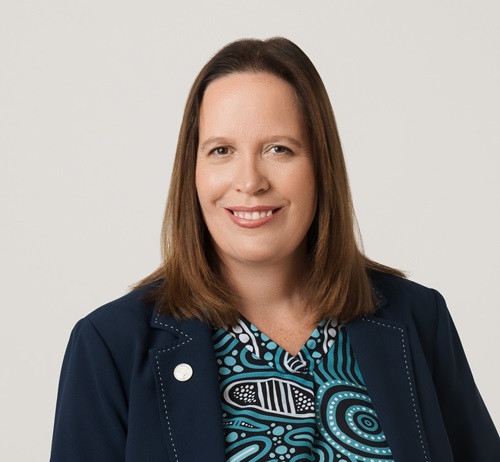 Woman with brown hair smiling at the camera. 