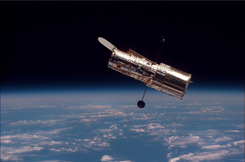 Hubble Space Telescope in space with Earth in the distance