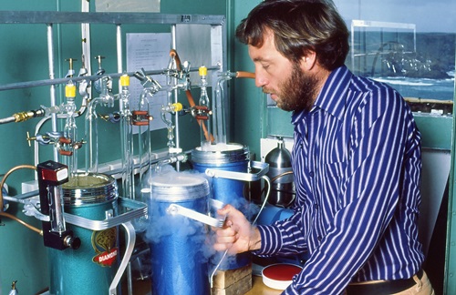 Scientist with a flask and clouds from liquid nitrogen coming from the lid