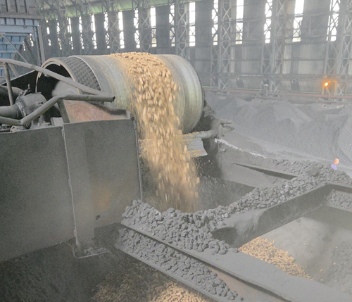 Rice pellets being loaded into hopper onto conveyor build carrying coal