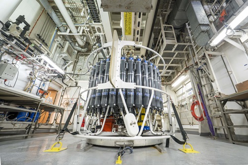 A large circular piece of scientific equipment strapped down onto the floor of a laboratory.