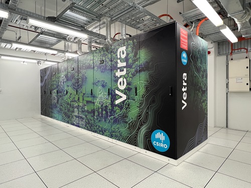 Wide view of a Vetra data centre installation showing multiple connected cabinets with landscape graphics and CSIRO branding inside a bright, modern server facility with exposed ceiling infrastructure.