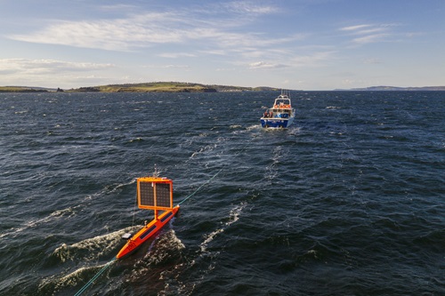 Orange USV being towed behind a boat in the harbour leaving Hobart