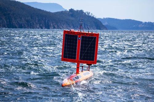Photo of the orange USV showing the solar panel from the front, in the water