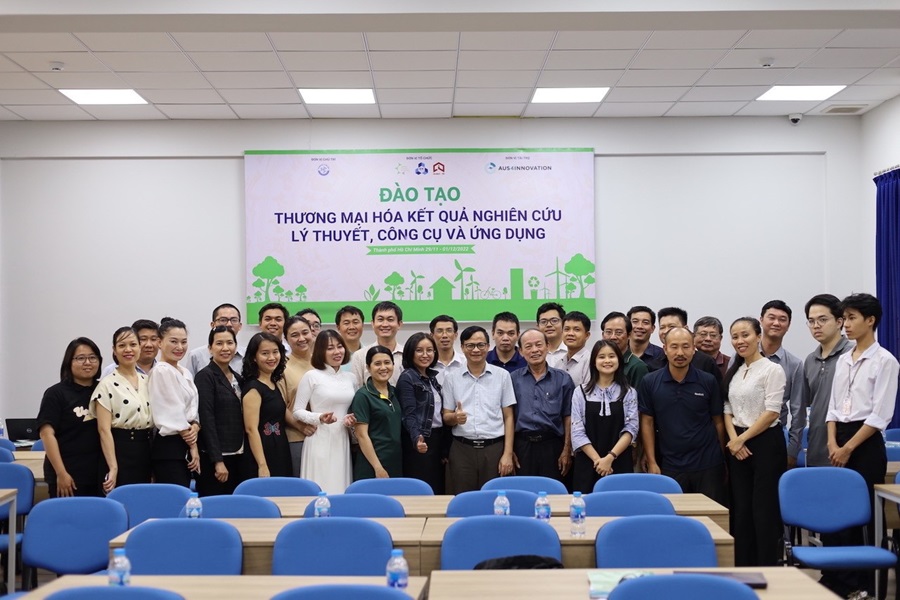 People standing at the end of a conference room smiling for a group photo. 