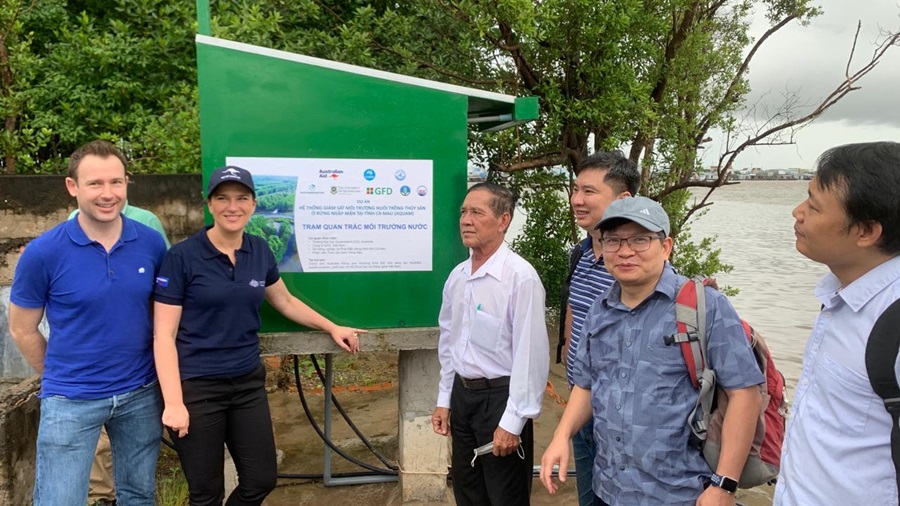 People in front of sign in a mangrove forest