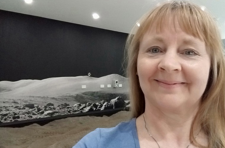 Dr Jane Hodgkinson smiling with lunar landscape image in background