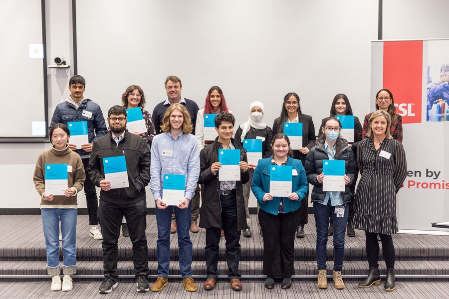 People holding certificates from a UROP conference standing together for a group photo. 