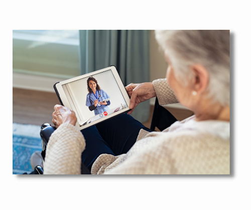 An elderly woman holding a tablet with a person in scrubs on the screen