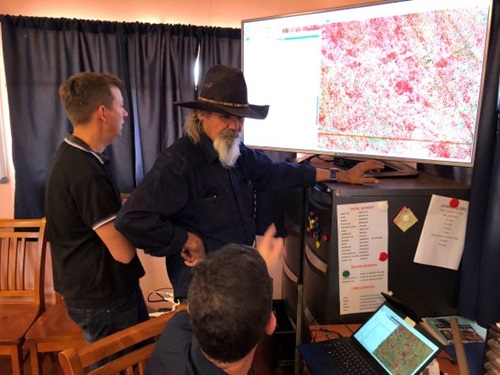Trevor Parker, Senior Custodian of Peedamulla, in front of screen talking with Steven Sonneman-Smith, Chief Executive Officer of Ashburton Aboriginal Corporation and CSIRO officer