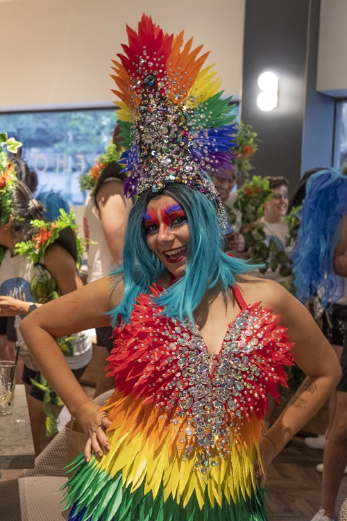 A person dressed in bright colours with a bright blue wig