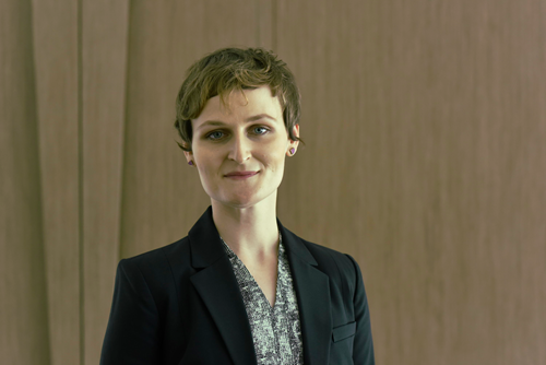 Woman with short hair wearing black business jacket.