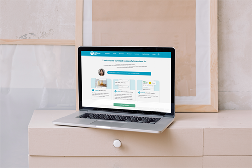 A laptop sits open on a chest of draws. The screen is open to the CSIRO Total Wellbeing Diet website