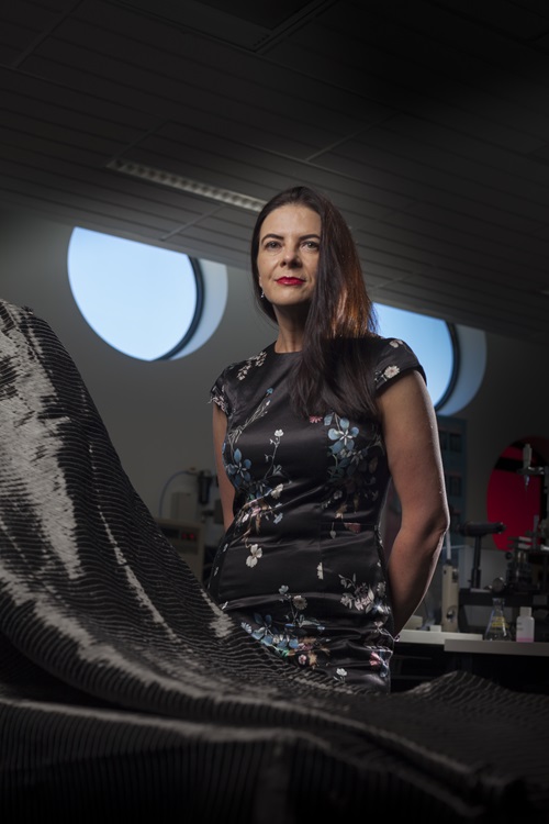 Scientist stands in front of scientific equipment