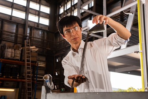 A scientist pours particles into his hand