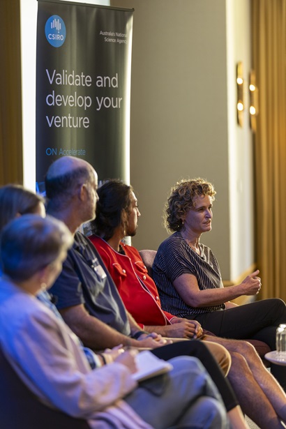 Panel discussion at a CSIRO ON Accelerate event, with several speakers seated on stage and one panellist speaking beside an ON Accelerate banner.