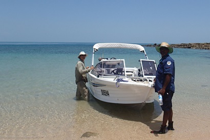 CSIRO scientist stands with an indigenous ranger infront of boat on the shore