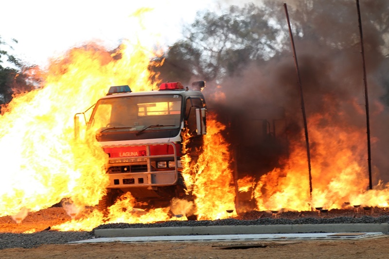A NSW rural fire truck is impacted by flames during testing at the Mogo facility in NSW. CSIRO testing of firefighting vehicles to support development of crew protection systems. 