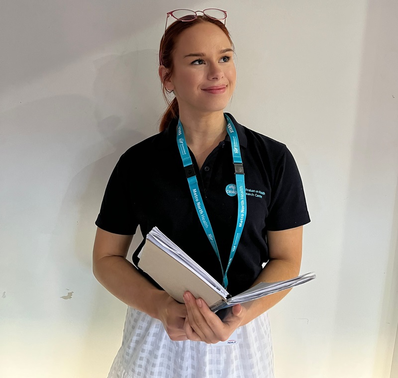 Young woman (Morgan) holds book and smiles 