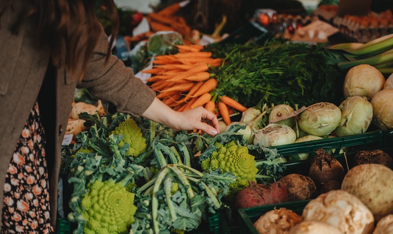 Hand reaching out towards a selection of winter vegetables