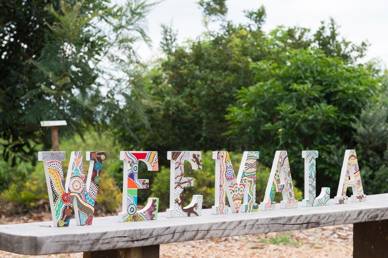 A sign in front of a garden reads Weemala.