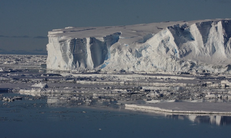 An ice front in the ocean surrounded by ice. 