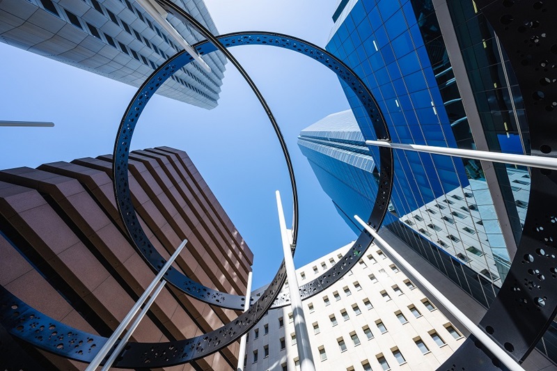 Circular sculpture with buildings in the background