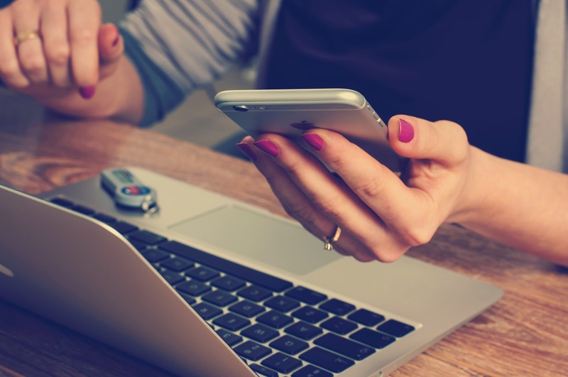 A person holding and looking at their mobile phone.