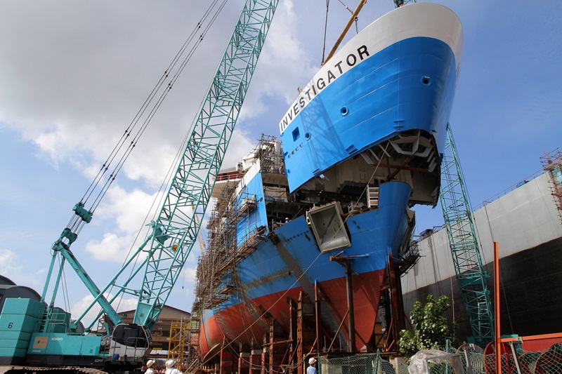 A large blue and white ship being constructed in pieces.