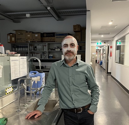 Man wearing clay face mask in lab