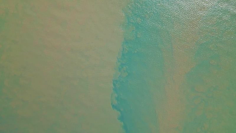 Brown sediment plume mixes with blue sea water at Darumbal Sea Country Keppel Bay.