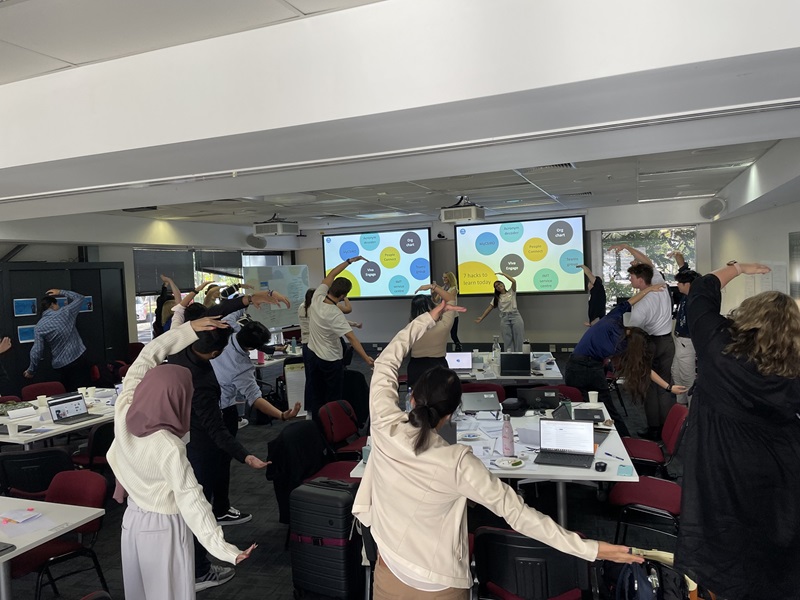 Graduate Program members doing a group exercise of stretches during GO Week