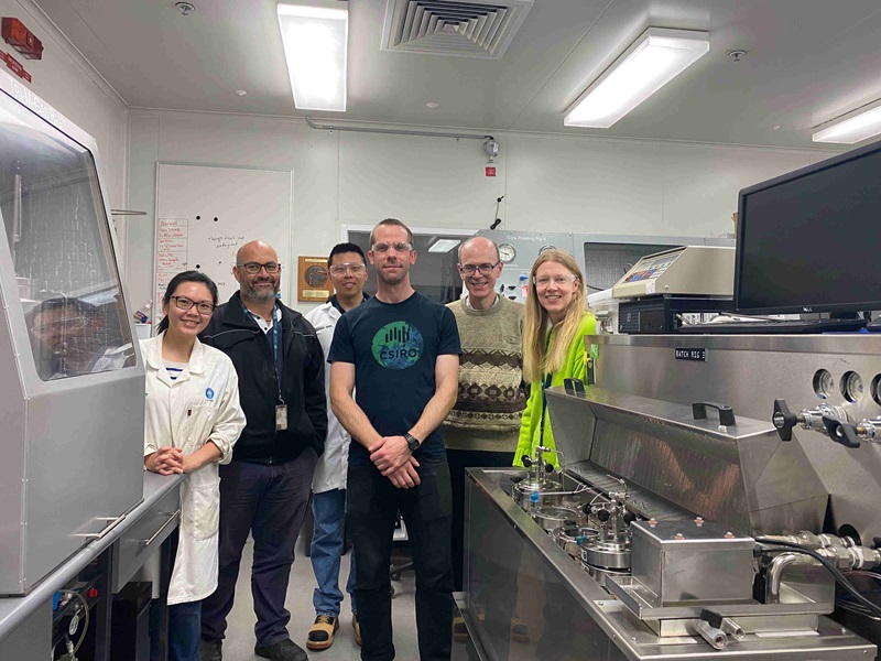 People in labcoats and CSIRO t-shirts posing in a laboratory