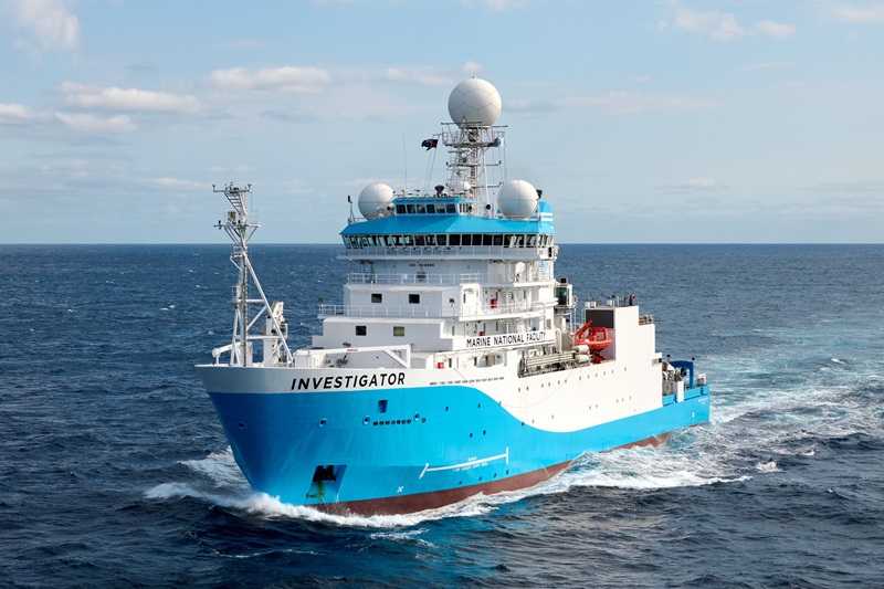 A large blue and white research vessel sailing on the ocean.