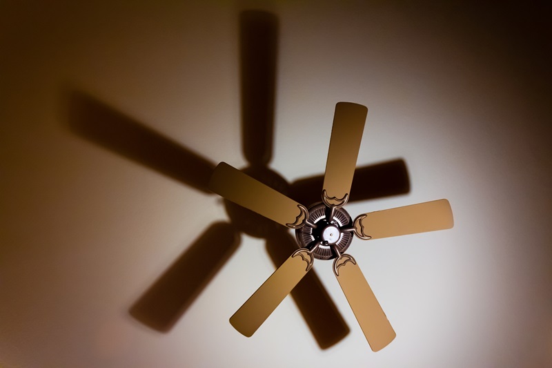 A ceiling fan throws a shadow on the ceiling. 