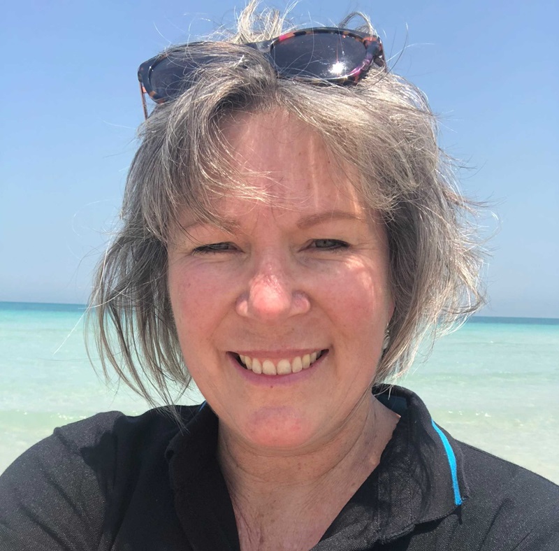 Headshot of CSIRO researcher Janet Anstee smiling with an ocean background behind her.