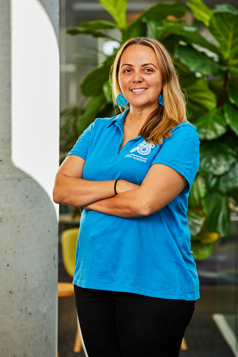 Sarah Landers is wearing a blue shirt and smiling at the camera