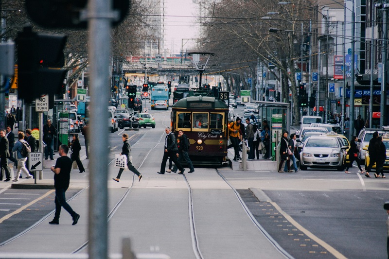 Street scene in Melbourne with a road view of people, trams and cars 