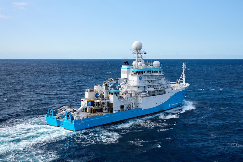 A blue and white ship sailing on the ocean.