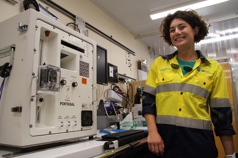 A person standing next to a piece of scientific equipment.