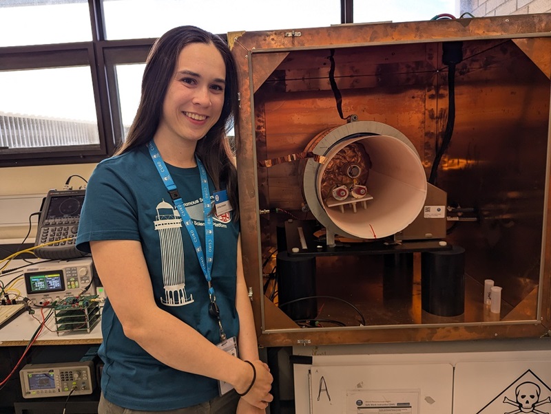 Woman standing next to wooden model