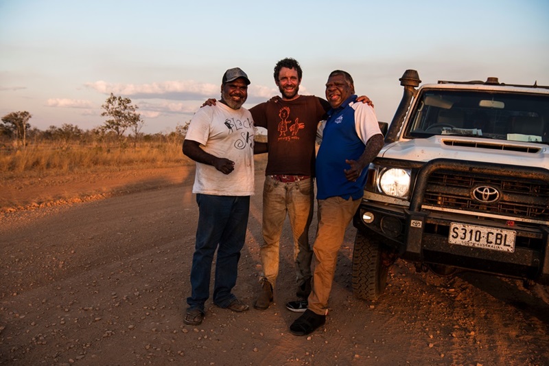 Pictured L to R: Jimmy Frank Jupurrurla, Simon Quilty and Norman Frank Jupurrurla leaning against a white Ute in outback Northern Territory. Picture by Andrew Quilty.