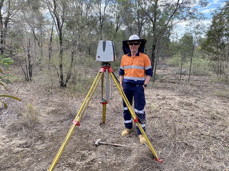 Man standing beside trip with scanner