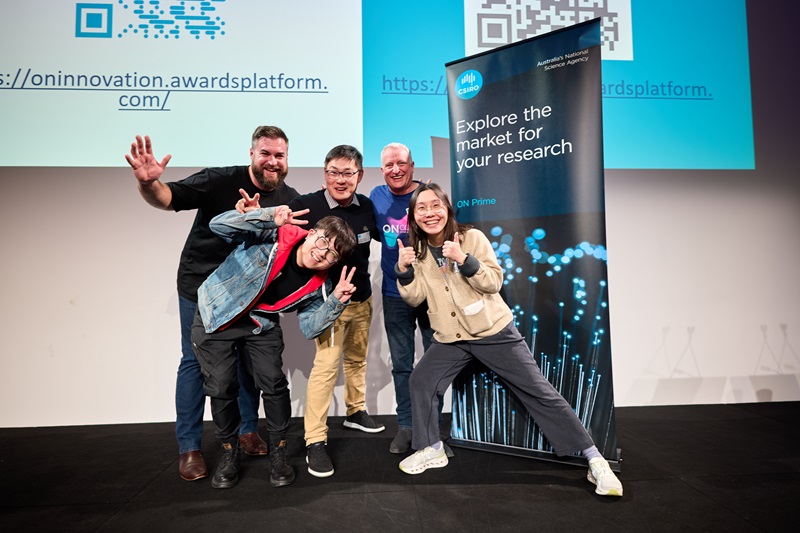 Five people posing for the camera in front of a CSIRO banner
