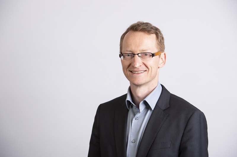 Head shot of Jon Whittle in a suit jacket facing the camera