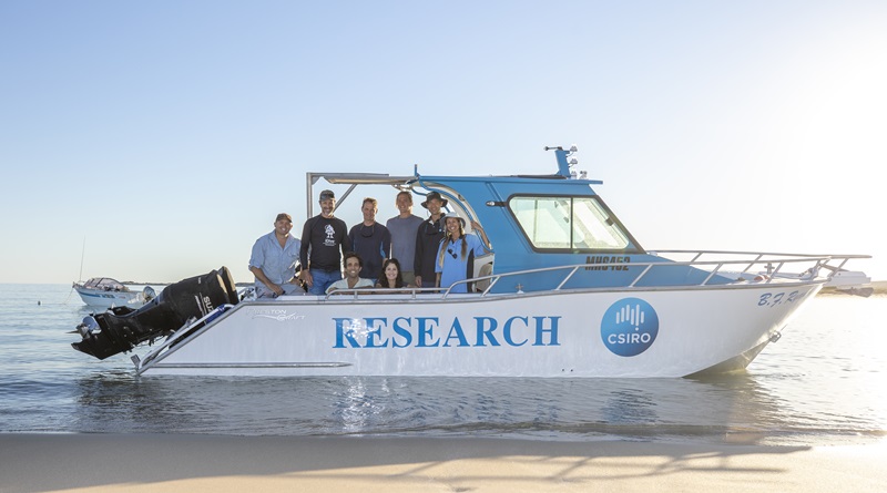 The Ningaloo Outlook research team gather aboard a CSIRO vessel by the shore. 