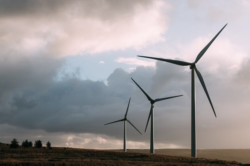 Three wind turbines against a cloudy sky